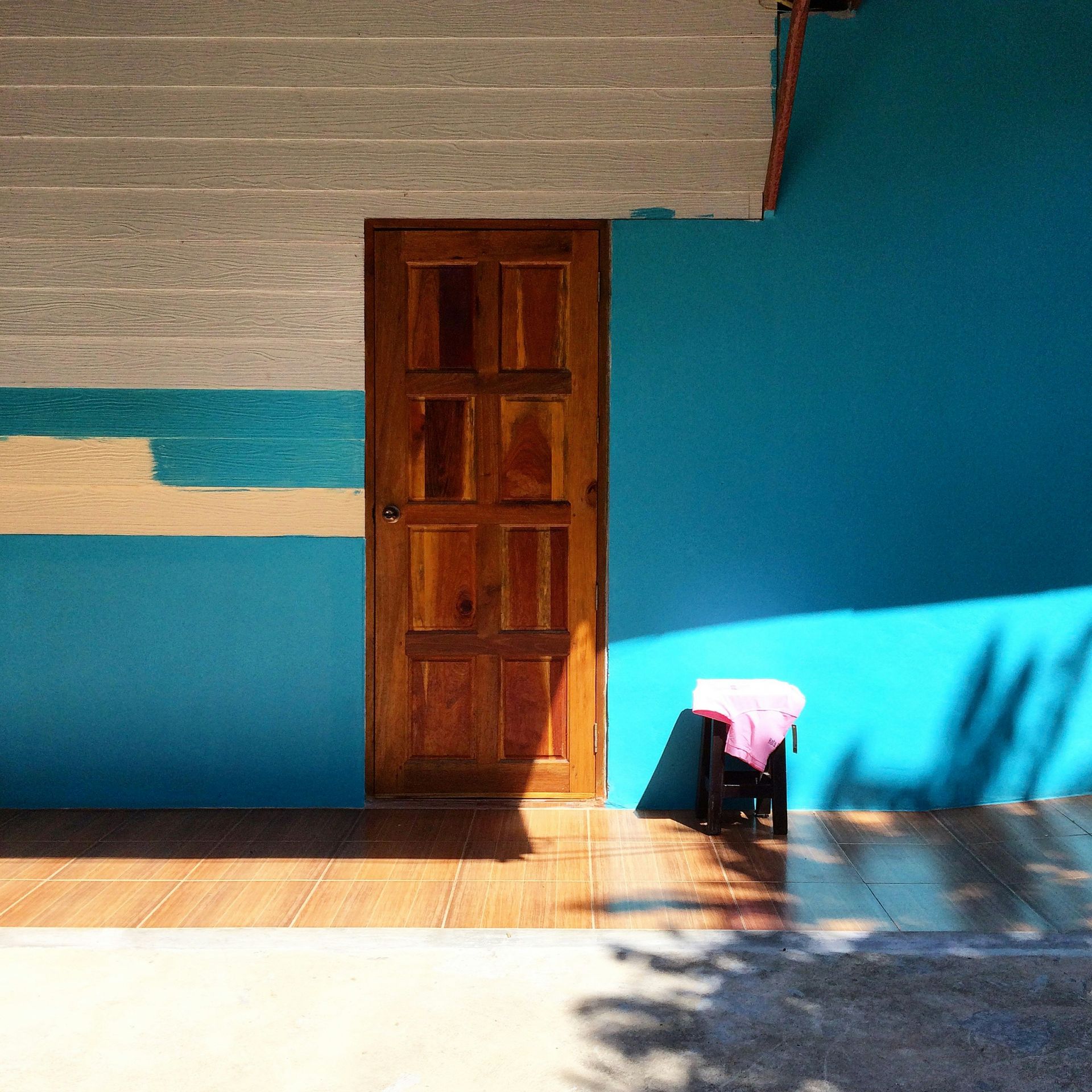 brown wooden shelf beside blue wall